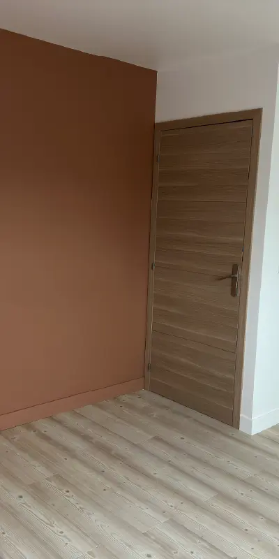 maison-granville-photo-verticale-04 Photo d'une chambre lors des travaux de la maison neuve de Granville, avec peinture mur et plafond, pose du parquet au sol.