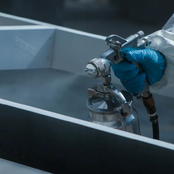 photo d'un mebre de l'équipe de rénovation qui peint un mur pendant un chantier de rénovation sur Agneaux (manche)